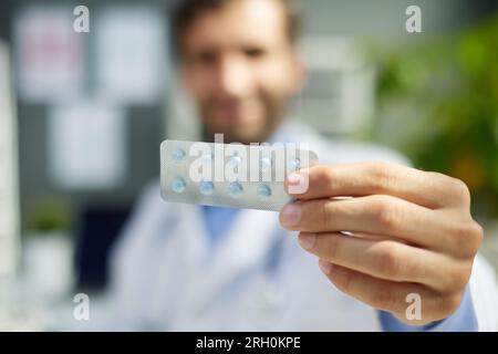 Ritratto ravvicinato dell'attraente farmacia del doc che tiene in mano una bottiglia di pillole organiche Foto Stock