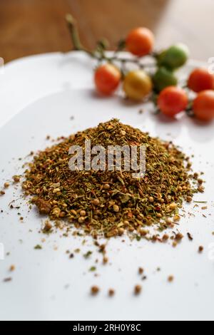 Miscela di spezie su una piastra bianca. Spezie e ingredienti per cucinare Foto Stock