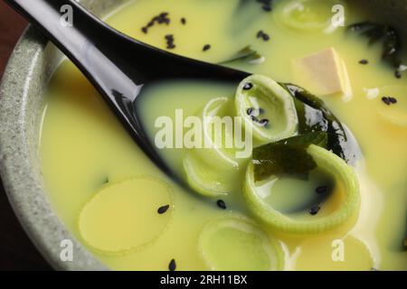 Ciotola di deliziosa zuppa di miso con tofu e cucchiaio, primo piano Foto Stock