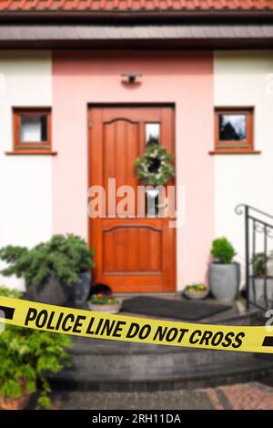 Nastro giallo della scena del crimine che blocca la casa all'aperto Foto Stock