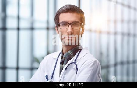 Ritratto di giovane infermiera maschile in corridoio ospedaliero Foto Stock