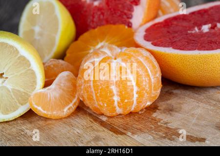 diversi tipi di agrumi in tavola, pompelmo rosso, mandarini arancioni e limone giallo in tavola Foto Stock