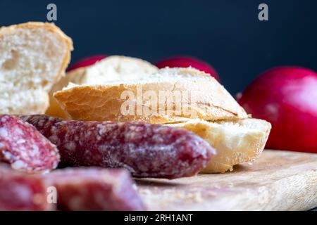 i pezzi di salsiccia affettati di carne sono sdraiati su un tagliere, la carne di maiale con la pancetta è secca e appassita, la carne è pronta per mangiare Foto Stock