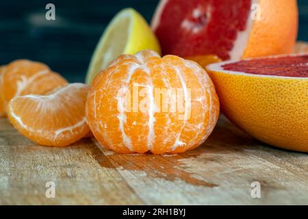 diversi tipi di agrumi in tavola, pompelmo rosso, mandarini arancioni e limone giallo in tavola Foto Stock