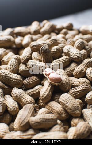 Vista dall'alto delle arachidi nella conchiglia, delle arachidi sgusciate e non sgusciate su un ripiano in marmo, vista dall'alto della noce nigeriana arrostita Foto Stock