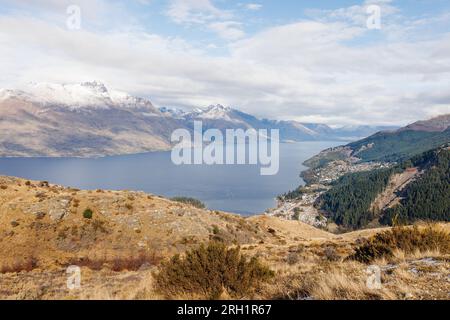 Una foto di Queenstown scattata dalla cima della passeggiata in collina di Queenstown. La foto contiene montagne innevate, la funivia dello skyline e uno splendido paesaggio Foto Stock