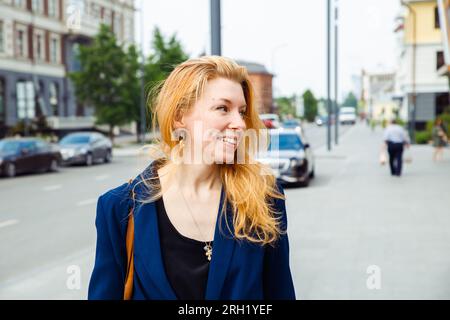 donna donna in abiti casual con capelli lunghi in strada. interior designer, architetto, donna d'affari. vista profilo verticale Foto Stock