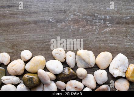 Ciottoli naturali sul fondo di uno sfondo di legno con spazio per la copia. Foto orizzontale orizzontale orizzontale orizzontale orizzontale orizzontale. Foto Stock