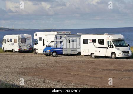 Quattro camper parcheggiati in un parcheggio non ufficiale, Cumbrian Coast, Maryport, Inghilterra, Regno Unito Foto Stock