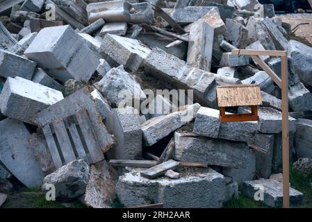 Alimentatore di uccelli contro frammenti di cemento Foto Stock