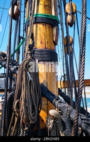 Albero di vecchio legno di barca a vela con corde corde. e la copertura Foto Stock