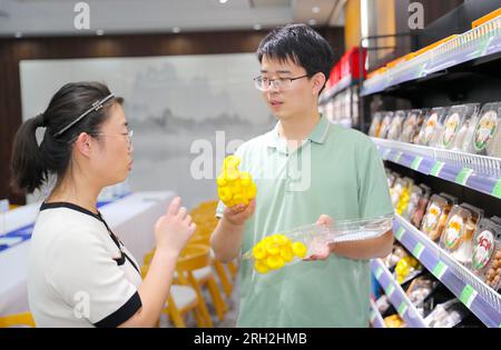 LAIXI, CINA - 13 AGOSTO 2023 - Un membro dello staff di un'impresa di coltivazione e trasformazione di funghi nella città di Laixi, provincia dello Shandong, introduce il mushr Foto Stock