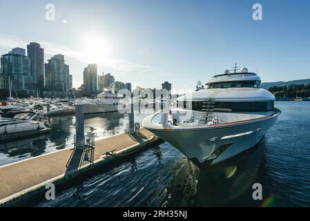 Un impressionante yacht privato è ormeggiato con barche più piccole nel porto di Vancouver, Canada Foto Stock