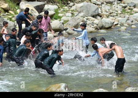 Doodhganga Yousmarg, Kashmir. Il 13 agosto, gli studenti del Kashmiri trovano sollievo dal caldo mentre si raffreddano nelle rinfrescanti acque di Doodhganga Yousmarg, trasformando una giornata soffocante in una fuga memorabile. Photos by Credit: Danish Showkat/Alamy Live News Foto Stock