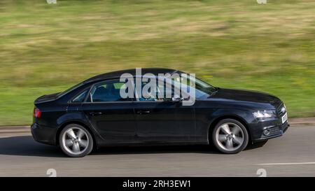 Milton Keynes, Regno Unito - 11 agosto 2023: Auto nera Audi A4 del 2011 che guida su una strada di campagna inglese. Foto Stock