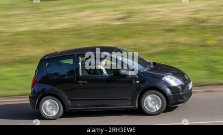 Milton Keynes, Regno Unito - 11 agosto 2023: Auto nera 2016 Suzuki Swift che guida su una strada di campagna inglese. Foto Stock