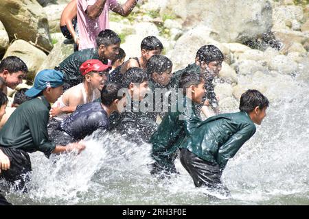 Doodhganga Yousmarg, Kashmir. Il 13 agosto, gli studenti del Kashmiri trovano sollievo dal caldo mentre si raffreddano nelle rinfrescanti acque di Doodhganga Yousmarg, trasformando una giornata soffocante in una fuga memorabile. Photos by Credit: Danish Showkat/Alamy Live News Foto Stock