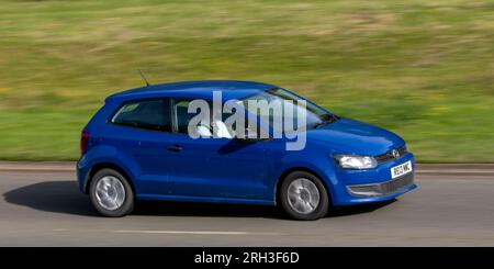 Milton Keynes, Regno Unito - 11 agosto 2023: Auto blu 2013 Volkswagen Polo che guida su una strada di campagna inglese. Foto Stock