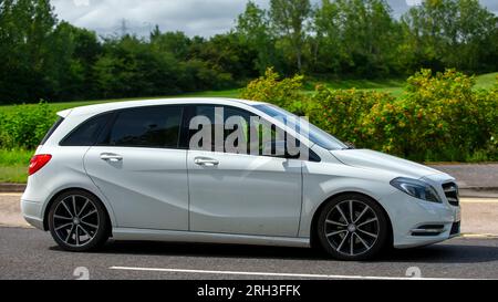 Milton Keynes, Regno Unito - 13 agosto 2023: 2013 Mercedes Benz Classe B B180 con motore diesel bianco che guida su una strada di campagna inglese. Foto Stock