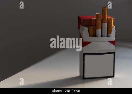 Concetto di fumare. Vuoto - nessun nome di pacchetti di sigarette isolato su sfondo nero, spazio per il testo. 3d illustrazione Foto Stock