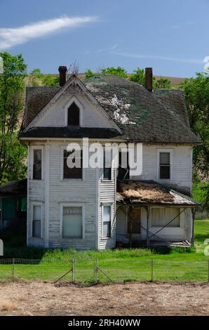 Una vecchia fattoria dall'aspetto spaventoso in un pomeriggio di sole a giugno. Columbia County, Washington, USA. Foto Stock