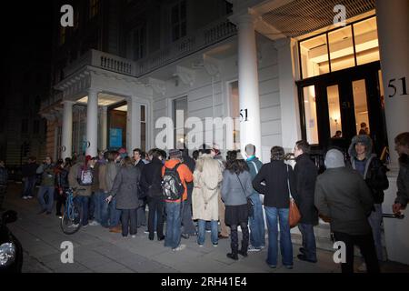 Persone che fanno la fila in un'unica fila fuori da un edificio a Londra . Foto Stock