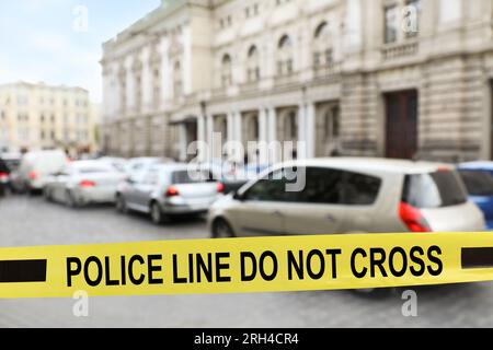 Nastro giallo della scena del crimine che blocca la strada Foto Stock