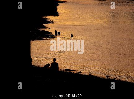 Londra, Regno Unito. 13 agosto 2023. Questa foto scattata il 13 agosto 2023 mostra persone lungo il Tamigi dopo il tramonto a Londra, in Gran Bretagna. Crediti: Li Ying/Xinhua/Alamy Live News Foto Stock