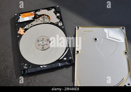 Dettaglio di un disco fisso per notebook evidenziato, a simboleggiare il supporto tecnico e il progresso tecnologico. Concetto tra assistenza tecnica e tecnologia Foto Stock