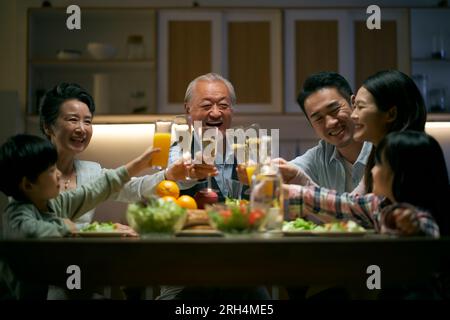 tre generazioni di famiglie asiatiche si riuniscono a casa per festeggiare una vacanza brindando Foto Stock