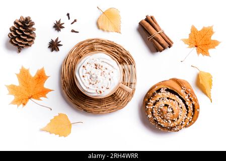 Composizione autunnale con caffè e Cinnamon Bun isolato su sfondo bianco. Tazza di caffè cappuccino con foglie gialle autunnali stagionali e pino C. Foto Stock