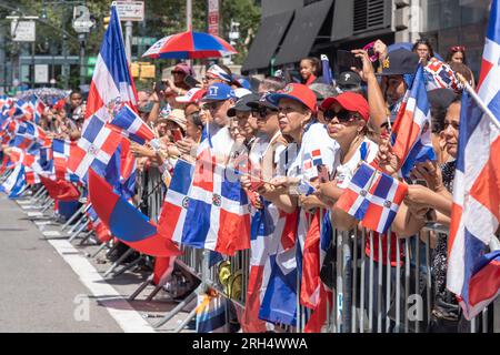 New York, Stati Uniti. 13 agosto 2023. NEW York, NEW YORK - 13 AGOSTO: Gli spettatori con le bandiere della Repubblica Dominicana guardano i manifestanti alla Dominican Day Parade sulla 6th Avenue il 13 agosto 2023 a New York City. La National Dominican Day Parade ha celebrato 41 anni di marcia sulla Sixth Avenue a Manhattan. La sfilata celebra la cultura, il folklore e le tradizioni dominicane. Crediti: Ron Adar/Alamy Live News Foto Stock