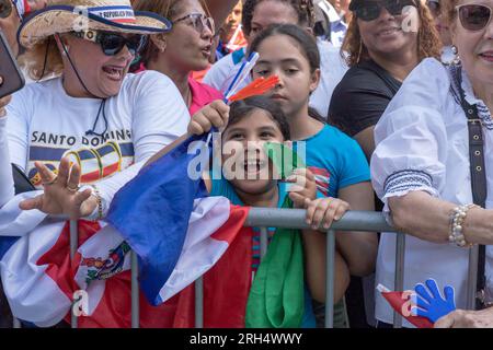 New York, Stati Uniti. 13 agosto 2023. NEW York, NEW YORK - 13 AGOSTO: Gli spettatori con le bandiere della Repubblica Dominicana guardano i manifestanti alla Dominican Day Parade sulla 6th Avenue il 13 agosto 2023 a New York City. La National Dominican Day Parade ha celebrato 41 anni di marcia sulla Sixth Avenue a Manhattan. La sfilata celebra la cultura, il folklore e le tradizioni dominicane. Crediti: Ron Adar/Alamy Live News Foto Stock