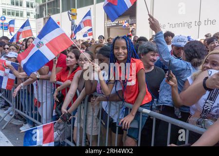 New York, Stati Uniti. 13 agosto 2023. NEW York, NEW YORK - 13 AGOSTO: Gli spettatori con le bandiere della Repubblica Dominicana guardano i manifestanti alla Dominican Day Parade sulla 6th Avenue il 13 agosto 2023 a New York City. La National Dominican Day Parade ha celebrato 41 anni di marcia sulla Sixth Avenue a Manhattan. La sfilata celebra la cultura, il folklore e le tradizioni dominicane. Crediti: Ron Adar/Alamy Live News Foto Stock