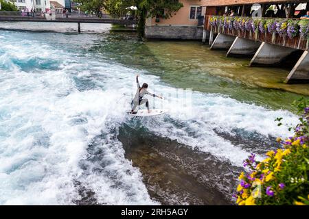 Donna che fa surf sul fiume all'Untere Schleuse Brücke a Thun, in Svizzera Foto Stock