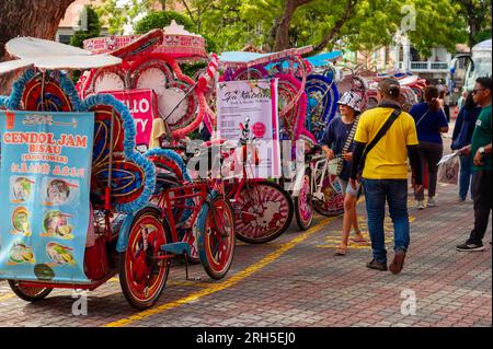 I rider del trishaw in cerca di affari a Stadthuys, Malacca, Malesia Foto Stock