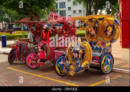 I rider del trishaw in cerca di affari a Stadthuys, Malacca, Malesia Foto Stock