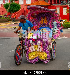 I rider del trishaw in cerca di affari a Stadthuys, Malacca, Malesia Foto Stock