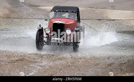 Un Riley 9 Special del 1932 si tuffa nella ford a Braughing, Hertfordshire, durante il VSCC Hertfordshire Harvest Tour del 2023. Foto Stock