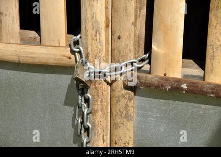 Lucchetto a catena su una recinzione in bambù Foto Stock