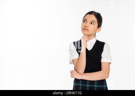 una studentessa pensiva in giubbotto nero che guarda lontano isolata sul bianco, pensante, uniforme scolastica, ragazzina Foto Stock