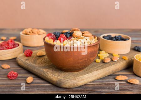 Cucinare una sana colazione. Granola con vari frutti secchi e noci in una ciotola. Il concetto di un dessert sano. Piano di giacitura, vista dall'alto con sp. Copia Foto Stock