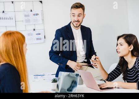 Persone aziendali sicure collaborano con team diversificati durante il briefing in ufficio Foto Stock