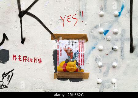 I contro-slogan anti-Pechino si vedono in Brick Lane. "Brick Lane a East London, storicamente celebrata per la sua eclettica Street art, è stata recentemente coinvolta in una controversa guerra dei graffiti. Il conflitto è iniziato sabato 5, quando un gruppo di artisti ha mostrato i "12 valori socialisti fondamentali" del Partito Comunista Cinese. In 24 caratteri cinesi rossi in grassetto su una parete di 100 metri. Questi valori sono "prosperità”, "democrazia”, "civiltà” e "armonia”; i valori sociali di "libertà”, "uguaglianza”, "giustizia” e "Stato di diritto”; e i valori individuali di "patriottismo”, "dedizione”, "integrità” e "f Foto Stock