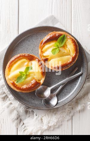 Mini crostate di torta di mele fresche fatte in casa con primi piani di menta in un piatto sul tavolo. Vista dall'alto verticale Foto Stock