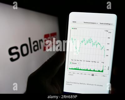 Persona che possiede uno smartphone con pagina Web dell'azienda israeliana SolarEdge Technologies Inc. Sullo schermo con logo. Concentrarsi sul centro del display del telefono. Foto Stock