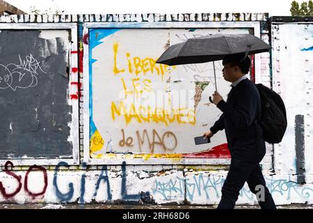 Londra, Regno Unito. 8 agosto 2023. Un uomo cammina davanti a uno slogan anti-Pechino "la libertà la scimmia di Mao" in Brick Lane. "Brick Lane a East London, storicamente celebrata per la sua eclettica Street art, è stata recentemente coinvolta in una controversa guerra dei graffiti. Il conflitto è iniziato sabato 5, quando un gruppo di artisti ha mostrato i "12 valori socialisti fondamentali" del Partito Comunista Cinese. In 24 caratteri cinesi rossi in grassetto su una parete di 100 metri. Questi valori sono "prosperità", "democrazia", "civiltà" e "armonia"; i valori sociali di "libertà", "uguaglianza", "giustizia" Foto Stock