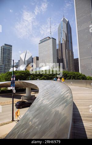 BP Pedestrian Bridge clad in brushed stainless-steel panels, Chicago, Illinois, USA, vertical portrait view with people crossing it Stock Photo