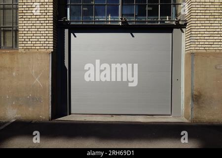 Ampio cancello scorrevole chiuso. Edificio urbano, vista esterna, non c'e' gente. Foto Stock