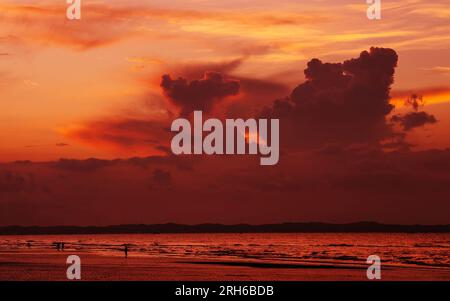 (230814) -- DONGXING, 14 agosto 2023 (Xinhua) -- i turisti si divertono all'alba sulla spiaggia di Jintan a Dongxing, nella regione autonoma di Guangxi Zhuang nel sud della Cina, 14 agosto 2023. La spiaggia di Jintan, situata nella parte meridionale dell'isola di Wanwei, ha una costa di 15 chilometri e prende il nome dal suo colore di sabbia dorata. (Xinhua/Fei Maohua) Foto Stock